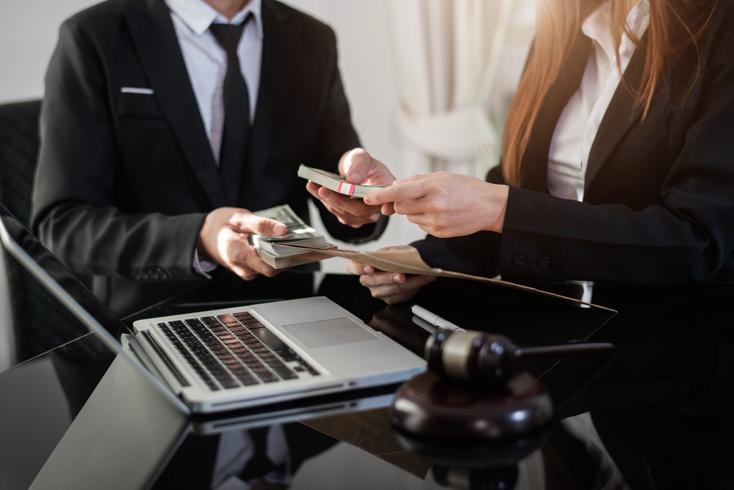 Businessman giving bribe money in the envelope to partner in a corruption scam in office.